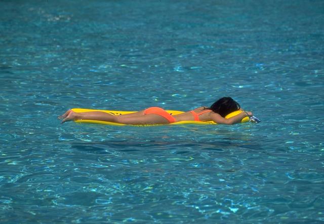 Mujer sobre una colchoneta en una piscina